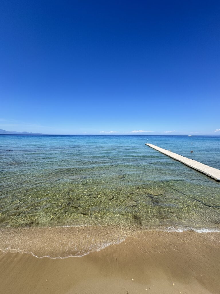 Helder turquoise zeewater met een steiger, symbool voor rust en loslaten tijdens vakantie als ondernemer
